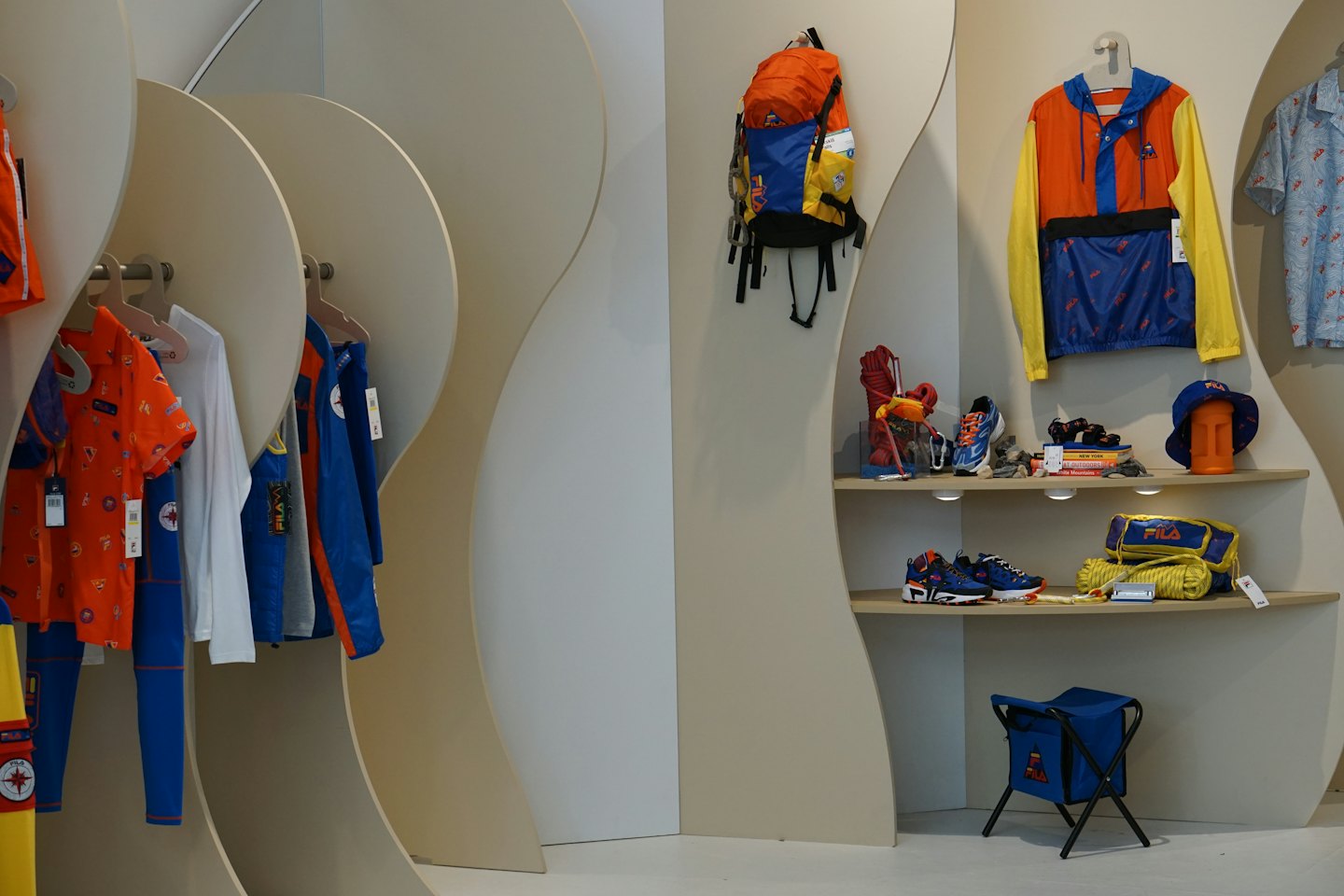 Sportswear and outdoor gear displayed on racks and wooden shelves.